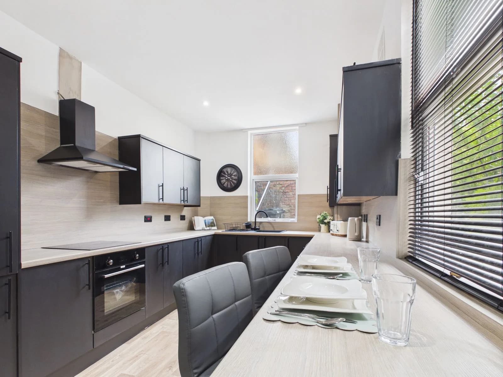 Kitchen and dining area with dark units, integrated oven and a breakfast bar at the completed Darlington HMO.